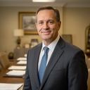 Managing partner in a Lake Charles law office standing beside a conference table with case files